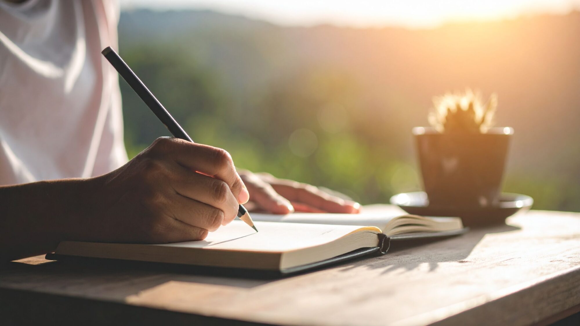 Person Writing in a Notebook Outdoors